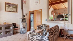 Una sala de estar con sofá, una mesa, un armario y una chimenea.