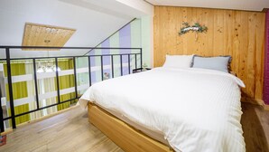 A bedroom with a wooden bed, a balcony with a black railing, and a wooden ceiling. - Supia Pension (Pyeongchang)