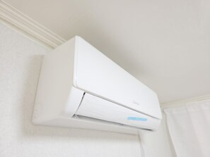A white air conditioning unit mounted on a wall.