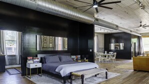 Ein Schlafzimmer mit einem Bett, Nachttischen, einem Schreibtisch und einem Sessel.