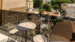 A balcony with a table and chairs, overlooking a cityscape with buildings and trees. - DKV Collection 15-Elegant Apt 2BedRooms Pigneto MetroC (Rome)