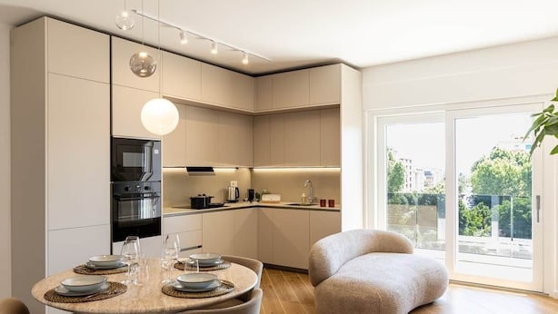 A modern kitchen with a dining area, large windows, and a view of the city. - DKV Collection 15-Elegant Apt 2BedRooms Pigneto MetroC (Rome)