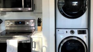 Una cucina compatta con forno a microonde, forno e lavasciuga impilata.