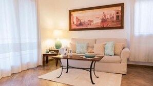 A living room with a sofa, a coffee table, a lamp, and a painting on the wall. - Sealine villa with an amazing view of Tavolara (olbia)