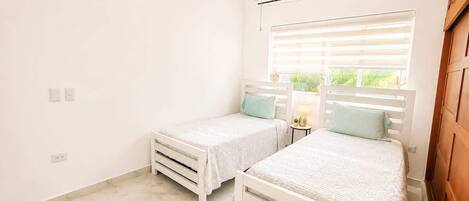 A bedroom with two beds, a window with blinds, an air conditioning unit, and a marble floor.