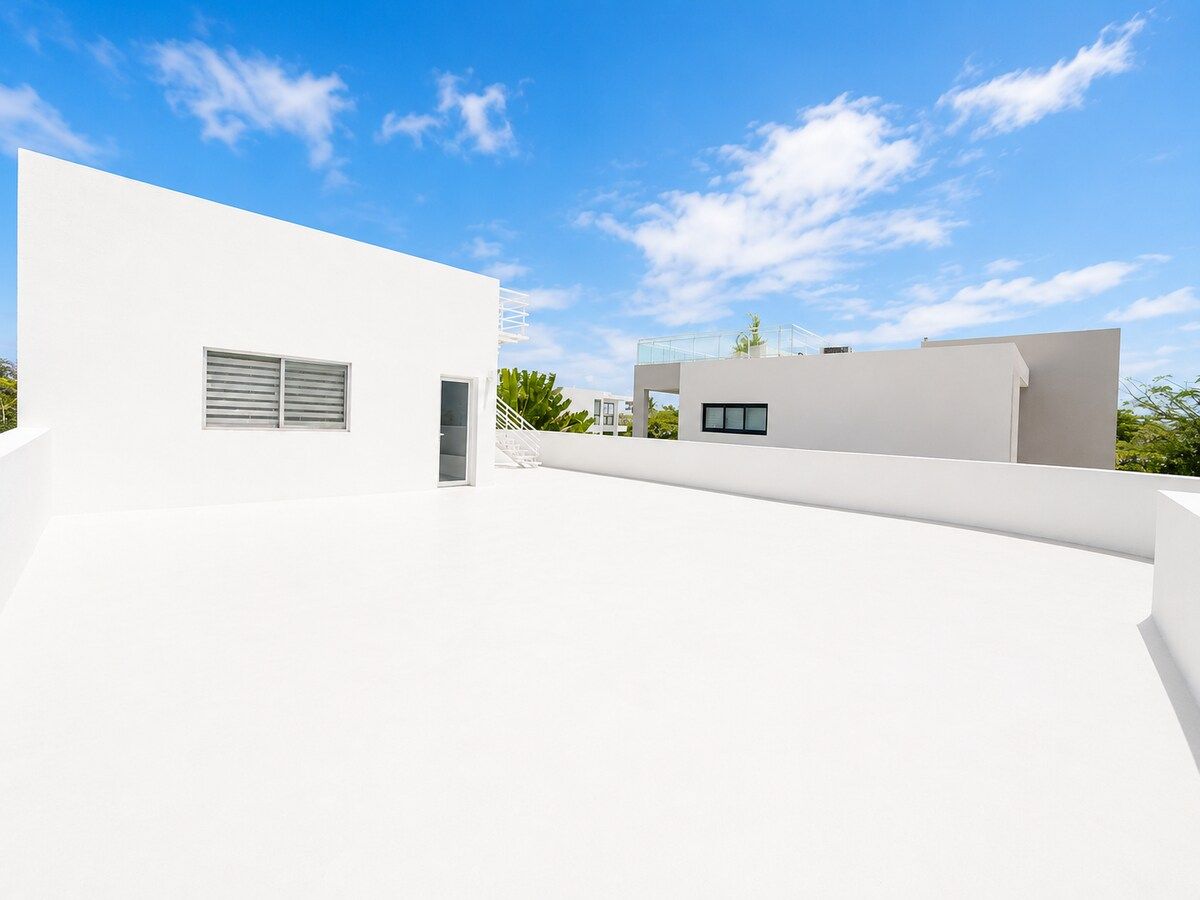 Un bâtiment moderne doté d’un toit plat, d’un escalier et d’une petite fenêtre.
