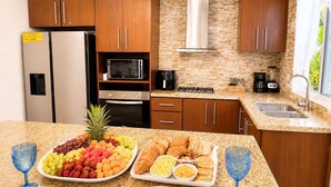 A modern kitchen with wooden cabinets, stainless steel appliances, and a granite countertop. - 3 Suites | L-Shaped Pool & Caribbean Retreat (Sosúa)