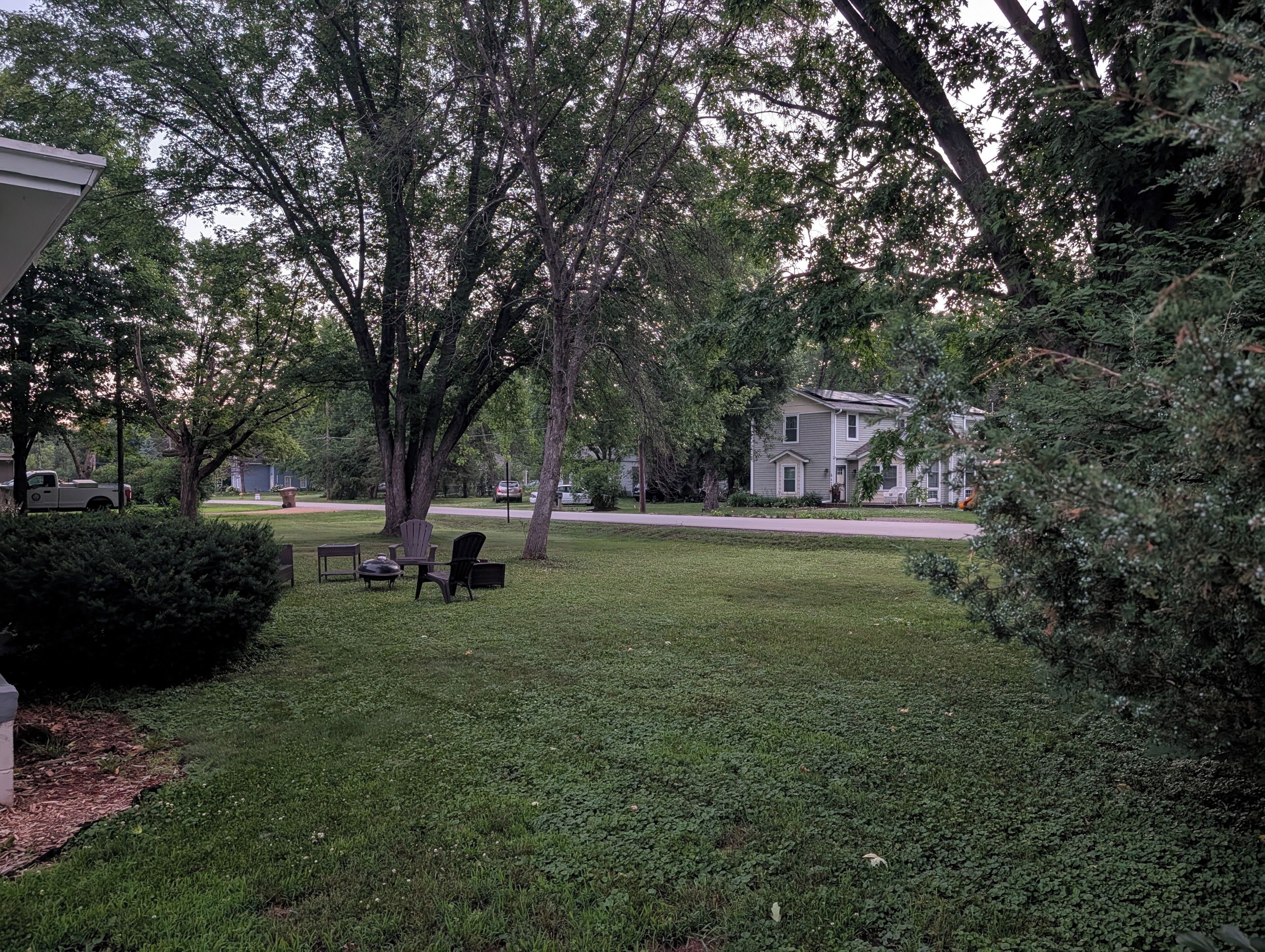 Un quartier résidentiel avec une pelouse verdoyante, des arbres et des maisons.