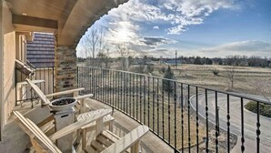 A balcony with a view of a rural landscape, a stone wall, and a metal railing. - Resort Style Family Fun with Guest House (Brighton)