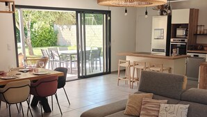 A modern living room with a sofa, coffee table, and dining area. - CASA NUBA - Modern villa with Jacuzzi - Between Provence & Mont Ventoux (Carpentras)