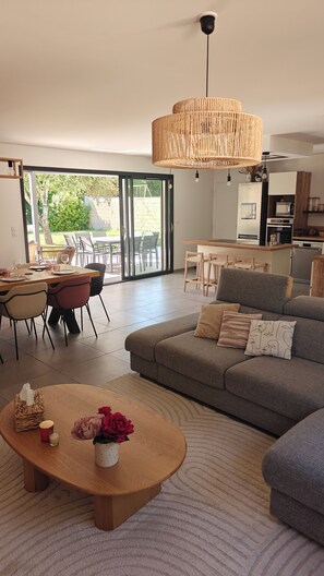 A modern living room with a sofa, coffee table, and dining area. - CASA NUBA - Modern villa with Jacuzzi - Between Provence & Mont Ventoux (Carpentras)