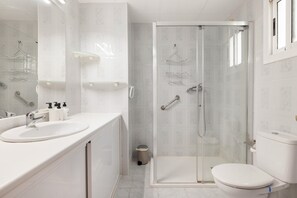 A modern bathroom with a glass-enclosed shower, a white sink, and a toilet. - 'Sobreático Salou' Apartment with Shared Pool, Wi-Fi, and Air Conditioning (Salou)