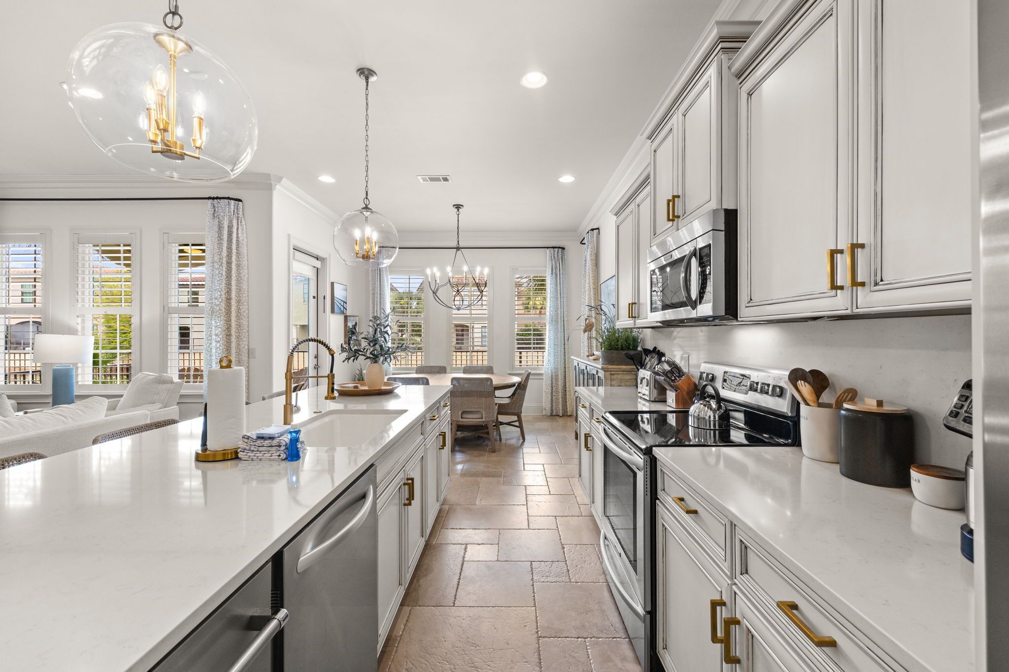 A modern kitchen with white cabinetry, stainless steel appliances, and a central island.