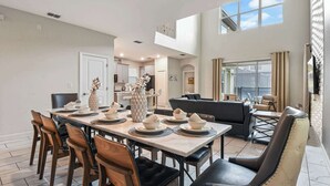 Uma sala de jantar com uma mesa comprida posta para seis pessoas, rodeada por cadeiras.
