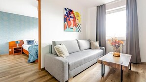 Una sala de estar moderna con un sofá gris, una mesa de centro de madera y un cuadro en la pared.