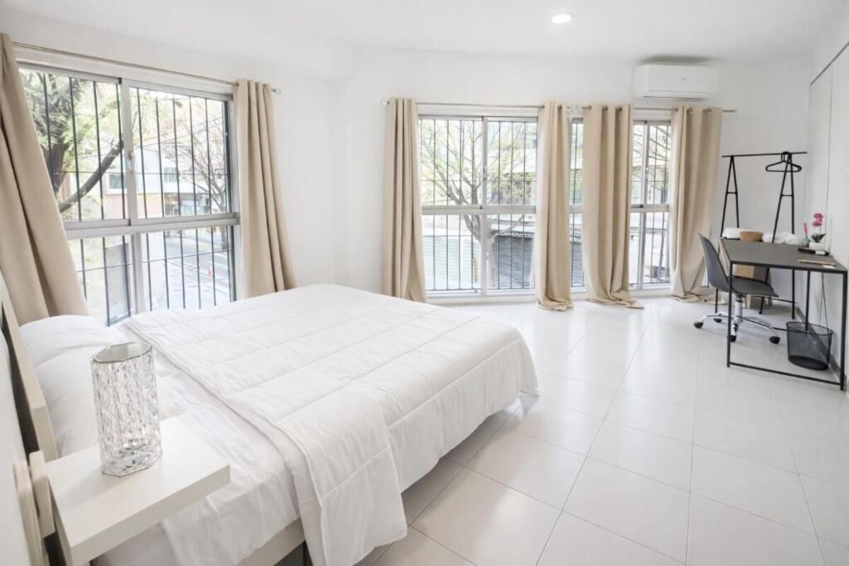 Una habitación de hotel con cama, escritorio y silla.