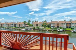 A waterfront hotel with a deck, marina, and row of buildings.