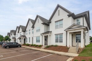A row of white buildings with grey roofs, numbered 108, and a parking lot in front. - Hotty Toddy Hideout (Oxford)