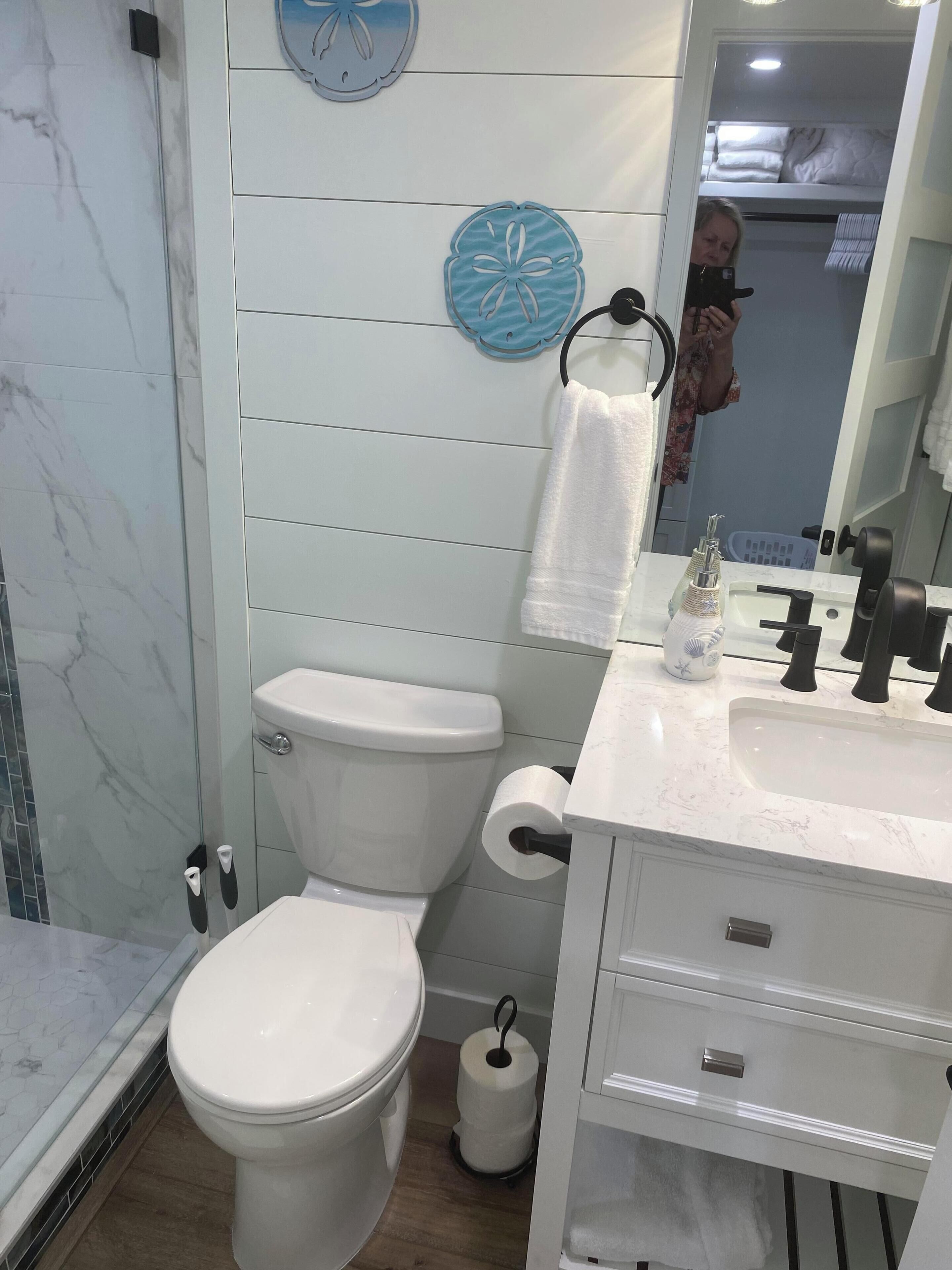 A bathroom with a toilet, sink, and mirror.