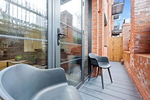 A balcony with a glass door, a wooden fence, and a brick wall. - Deluxe pad– Bham Centre, Pool Table, Next to Canal +Netflix (Birmingham)
