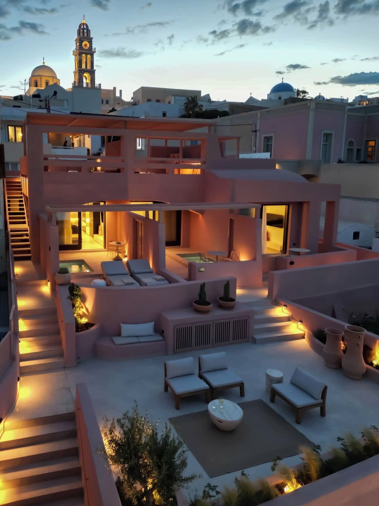A modern multi-story building with outdoor seating areas, a pool, and a staircase.