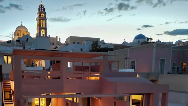 A modern multi-story building with outdoor seating areas, a pool, and a staircase. - Thianne Luxury Suites (Fira)
