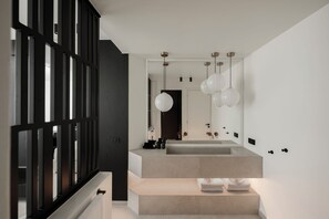 Deluxe suite | Badkamer | Een douche, een haardroger, handdoeken, shampoo