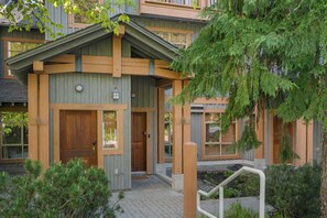 En modern byggnad med en träfasad, en ytterdörr och en liten veranda.