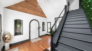 A staircase with a black handrail leading to a landing. - Venue 1925 with pool (Belton)