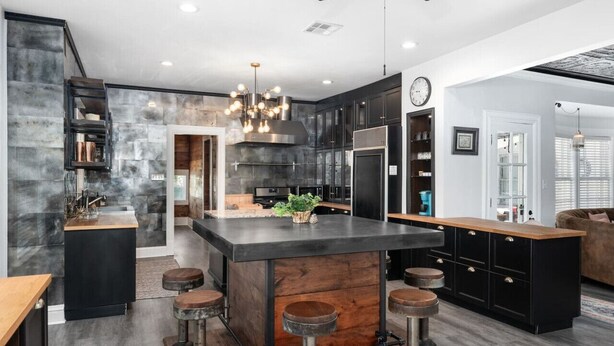 A modern kitchen with a central island, bar stools, and a ceiling fan. - Venue 1925 with pool (Belton)