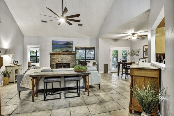 A spacious living area with a fireplace, a dining table, and a kitchen area.