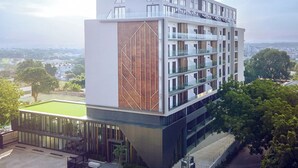 A modern multi-story building with a flat roof, large windows, and a mix of glass and solid facade materials. - One Bedroom Apartment at The Lennox (Accra)