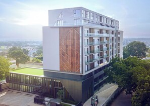 Ein modernes, mehrgeschossiges Gebäude mit flachem Dach, großen Fenstern und einer Fassade aus Glas und festen Materialien.