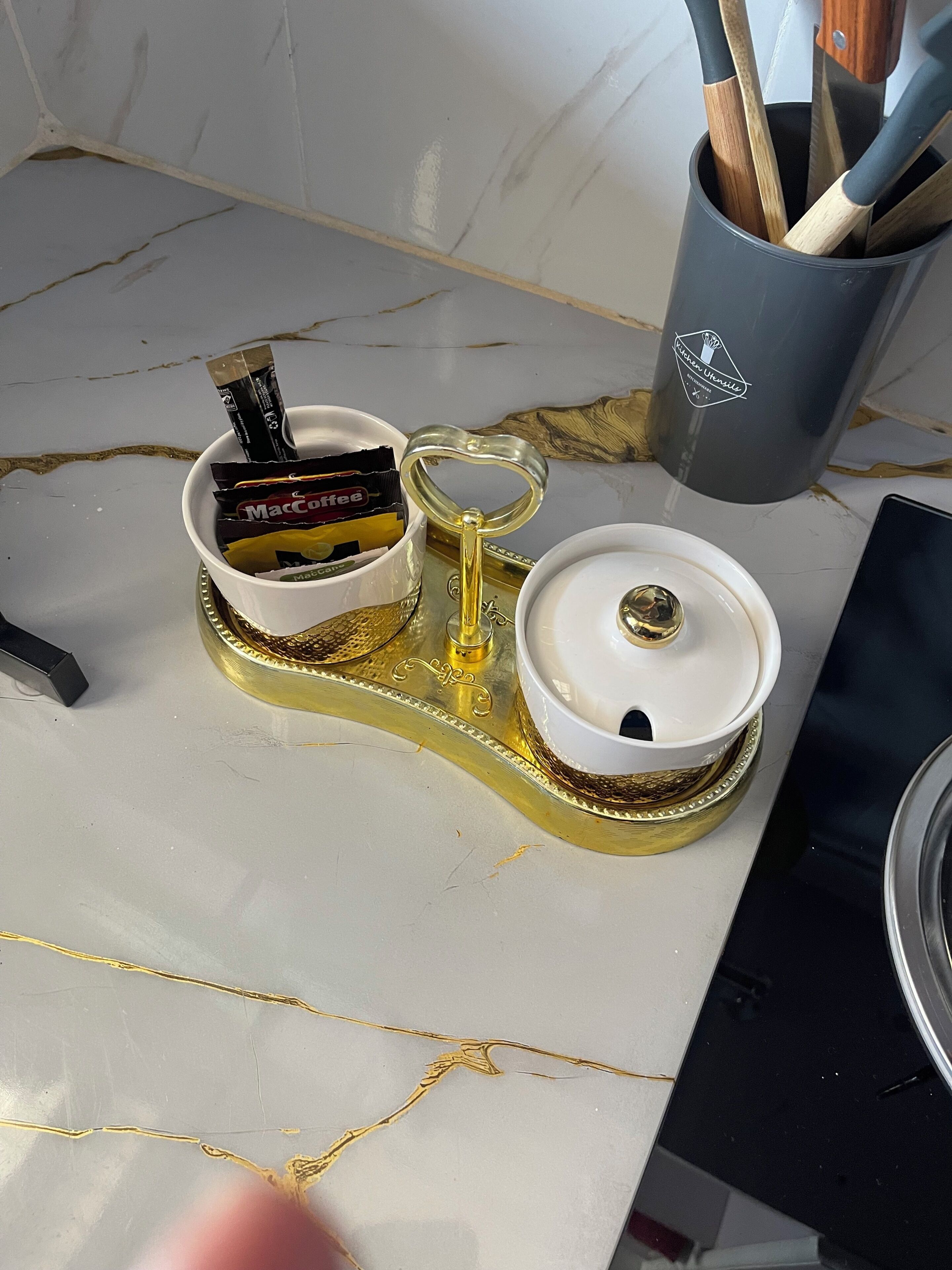 Eine Küchenarbeitsplatte mit einer Kaffeemaschine, einer Kaffeetasse und einer Aufbewahrungsbox für Kaffeekapseln.