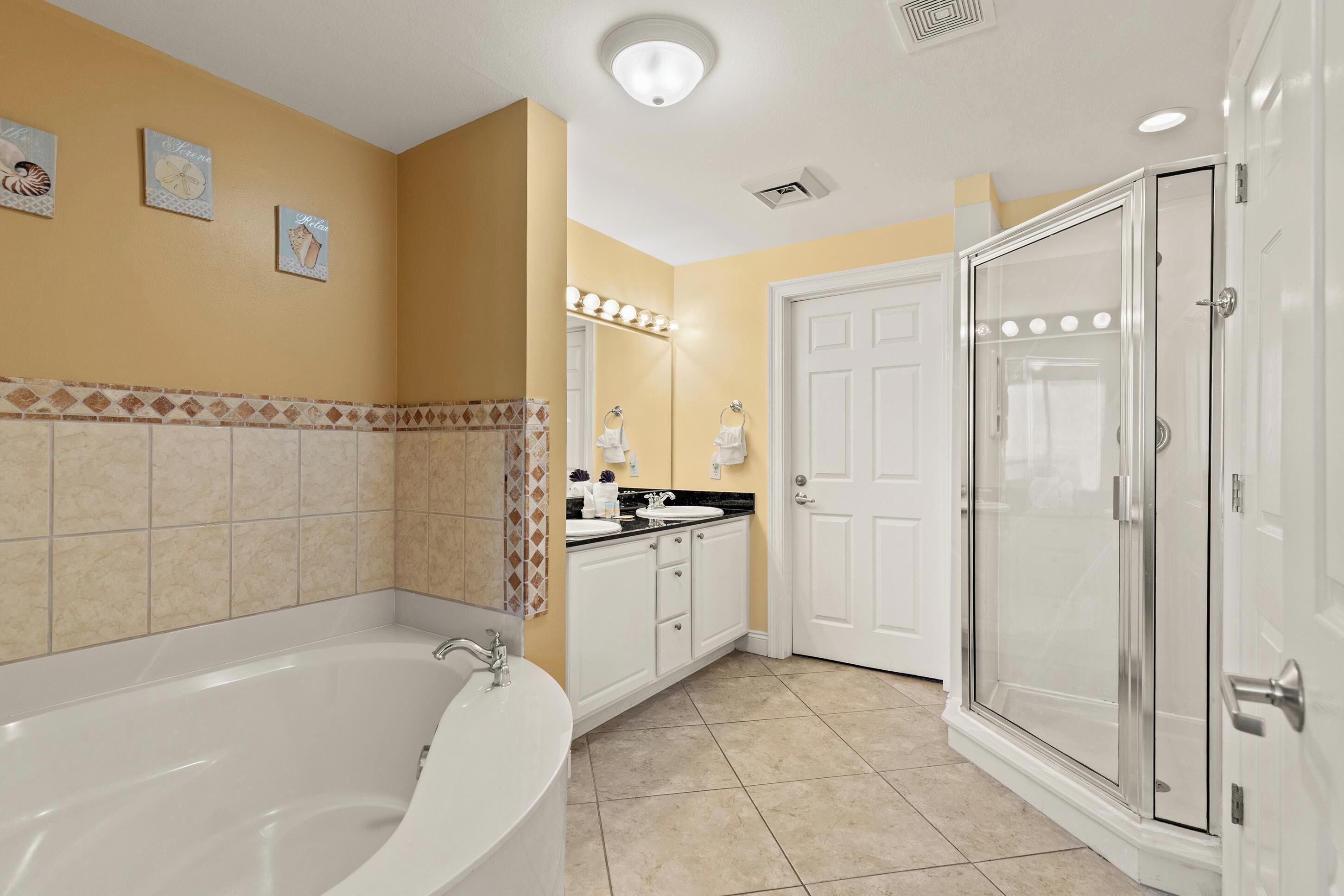 A bathroom with a bathtub, a shower, and a vanity with a sink.