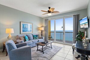 Un soggiorno con divano, tavolino e televisione. Include un balcone con vista sull'oceano.