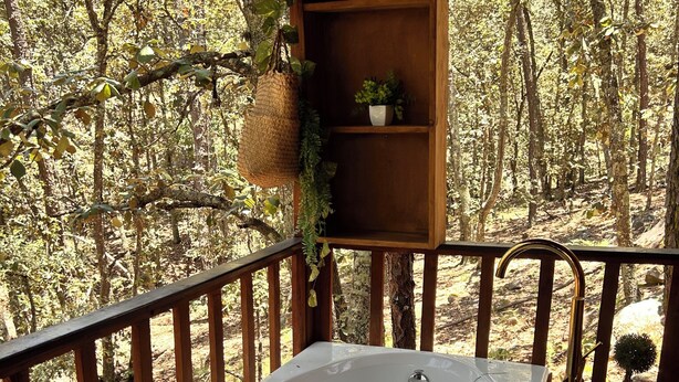 A hot tub on a wooden deck with a view of a forest. - Villas Bosque Alto By GEstores (Huasca de Ocampo)