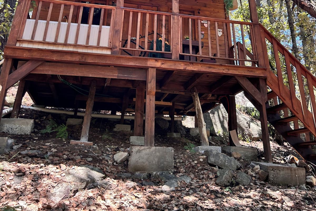 Eine Holzhütte mit Balkon, umgeben von Bäumen.
