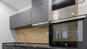 Una cucina moderna con forno, microonde e pensili in acciaio inossidabile.