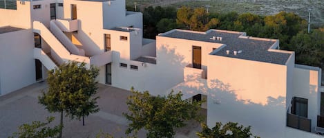 Un bâtiment moderne doté d’un toit plat, de nombreux balcons et d’un escalier.