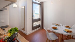 A modern kitchen with a dining area, a large window, and a view of the outdoors.