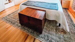 A bedroom with a bed, a ceiling fan, a window with curtains, a bedside table, and a nightstand. - Modern House Near ACU, HSU, Hendrick North (Abilene)