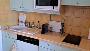Una cocina equipada con lavavajillas Bosch, microondas, tostadora y fregadero.