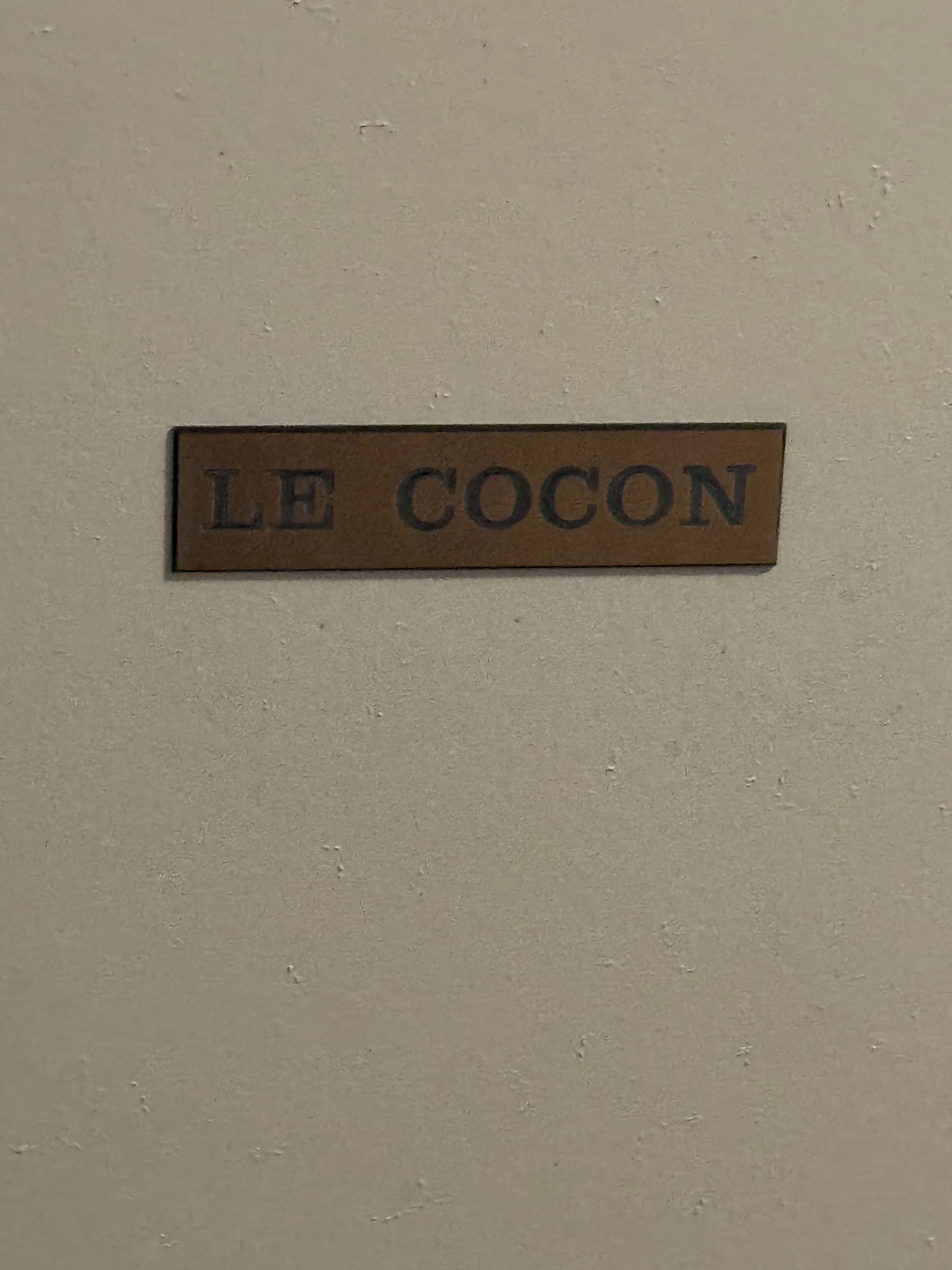 A sign with the text 'LE COCON' on a wall.