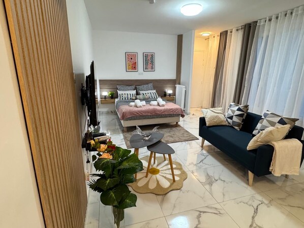 Une chambre à coucher moderne avec un lit, une table de chevet et un canapé.