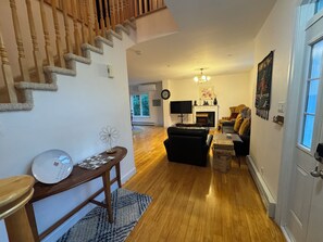 Ein Wohnzimmer mit Kamin, einer Couch, einem Couchtisch und einer Treppe.