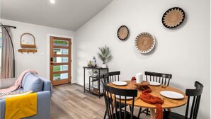 Un comedor con una mesa redonda, sillas y adornos en la pared.