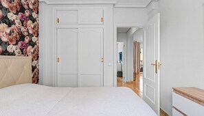 Ein Schlafzimmer mit einem Bett, einem Kleiderschrank und einer Tür zu einem anderen Raum.