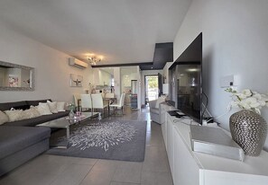 Ein modernes Wohnzimmer mit einer Couch, einem Couchtisch und einem dekorativen Teppich.