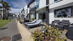 A modern hotel with outdoor seating, a pathway, and a well-maintained garden. - Groundfloor, oasis beach VI la zenia (La Zenia)